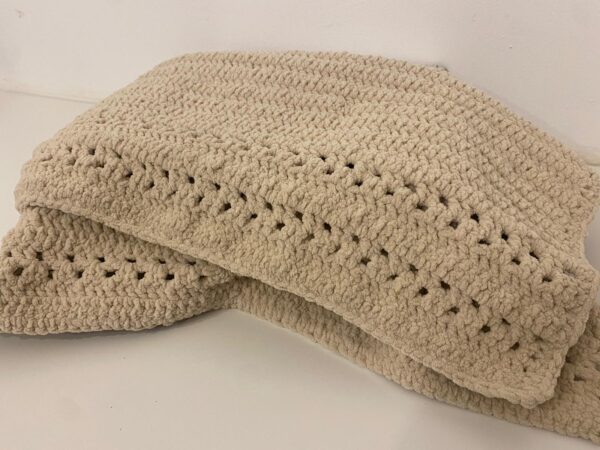 The Oliver crochet blanket, made with an off white, cream wool, in a stunning crochet pattern.