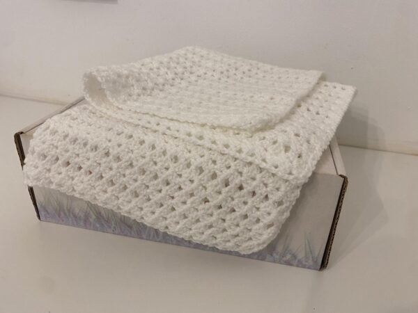 The Kane crochet blanket, a made with a stunning all white wool in a unique crochet pattern.