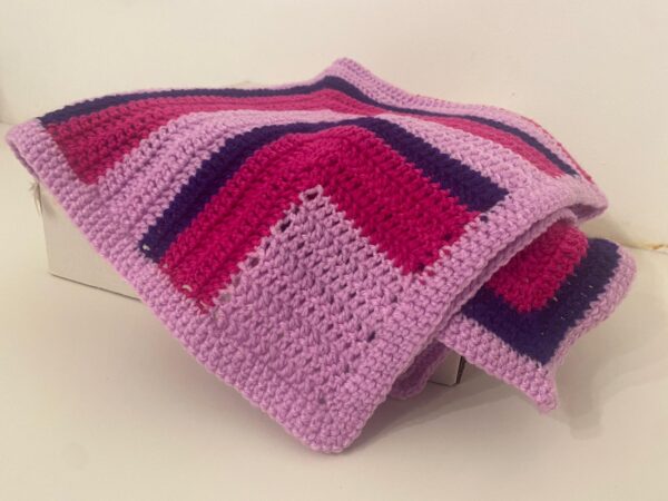 The Caoimh e crochet blanket. Made with two shades of pink and purple in a unique crochet pattern.
